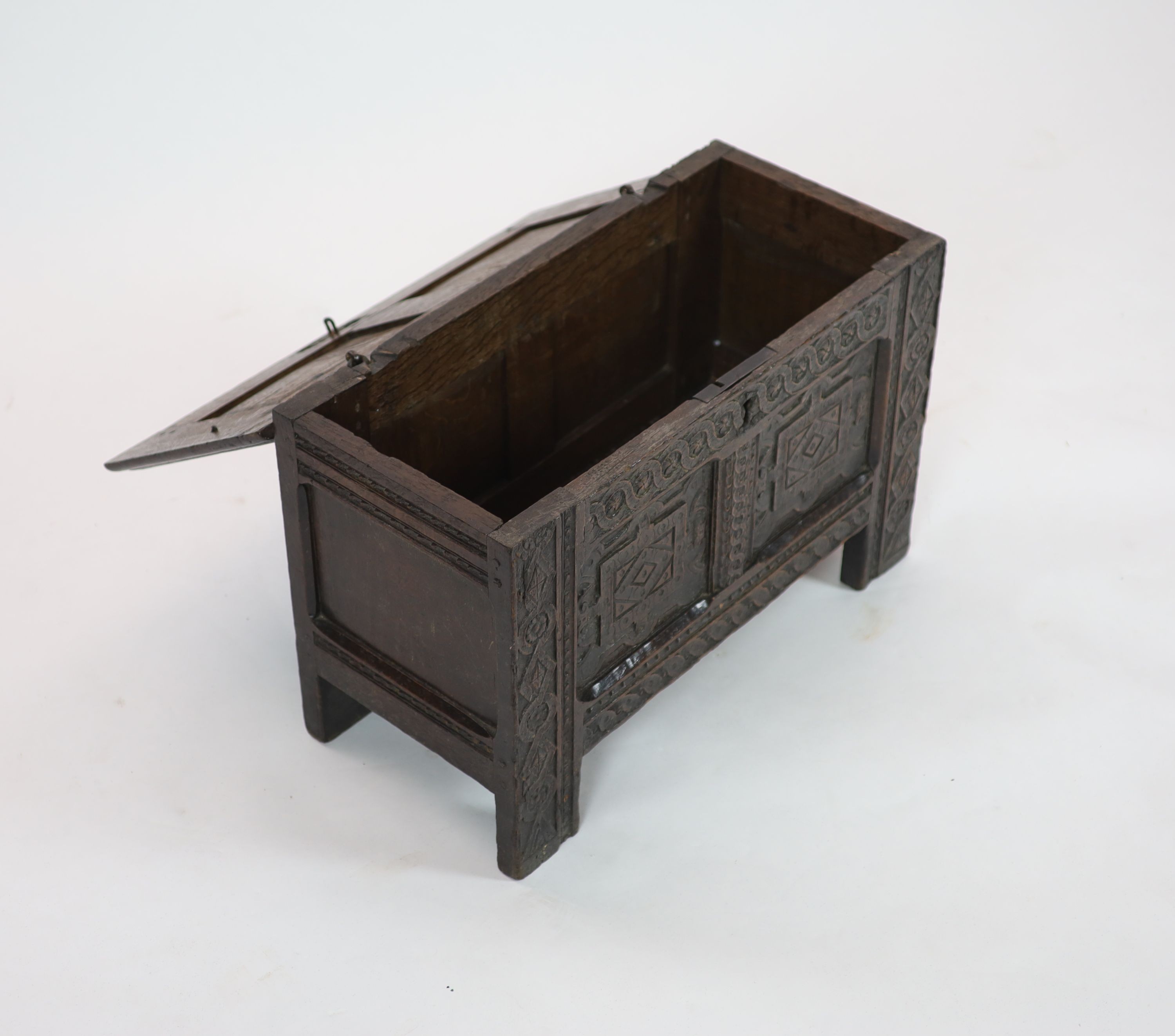 A late 17th/early 18th century small oak coffer (possibly West Country) the panelled front with Renaissance style carving H 46cm. W 70cm. D 34cm.